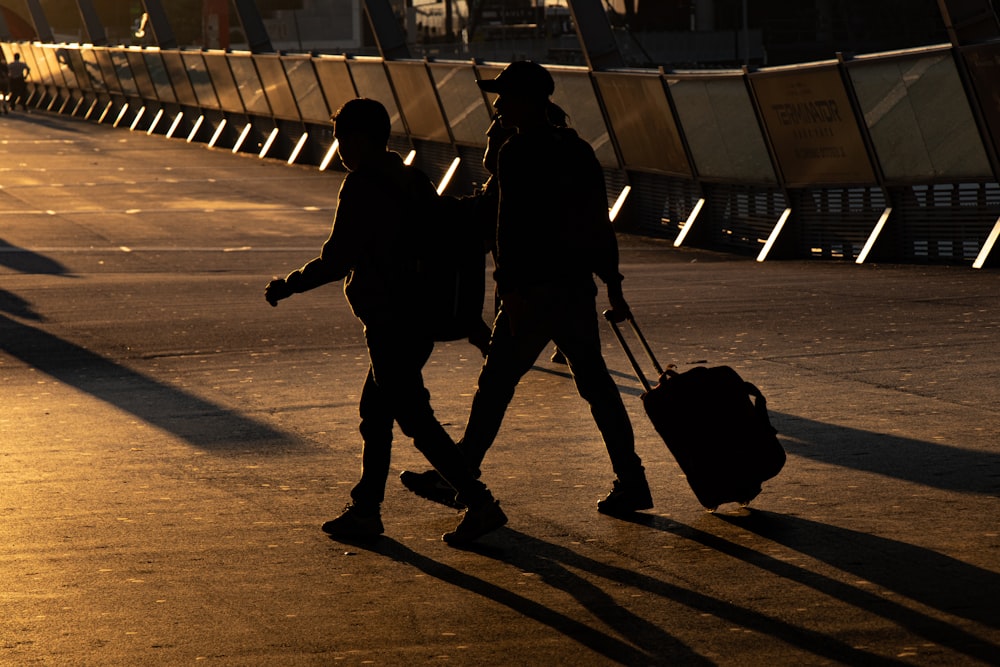 two person walking on road