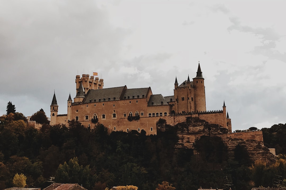 beige concrete castle on top of hill under white skies