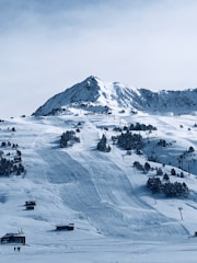 aerial photography of people near houses and field covered with snow under white and blue sky during daytime