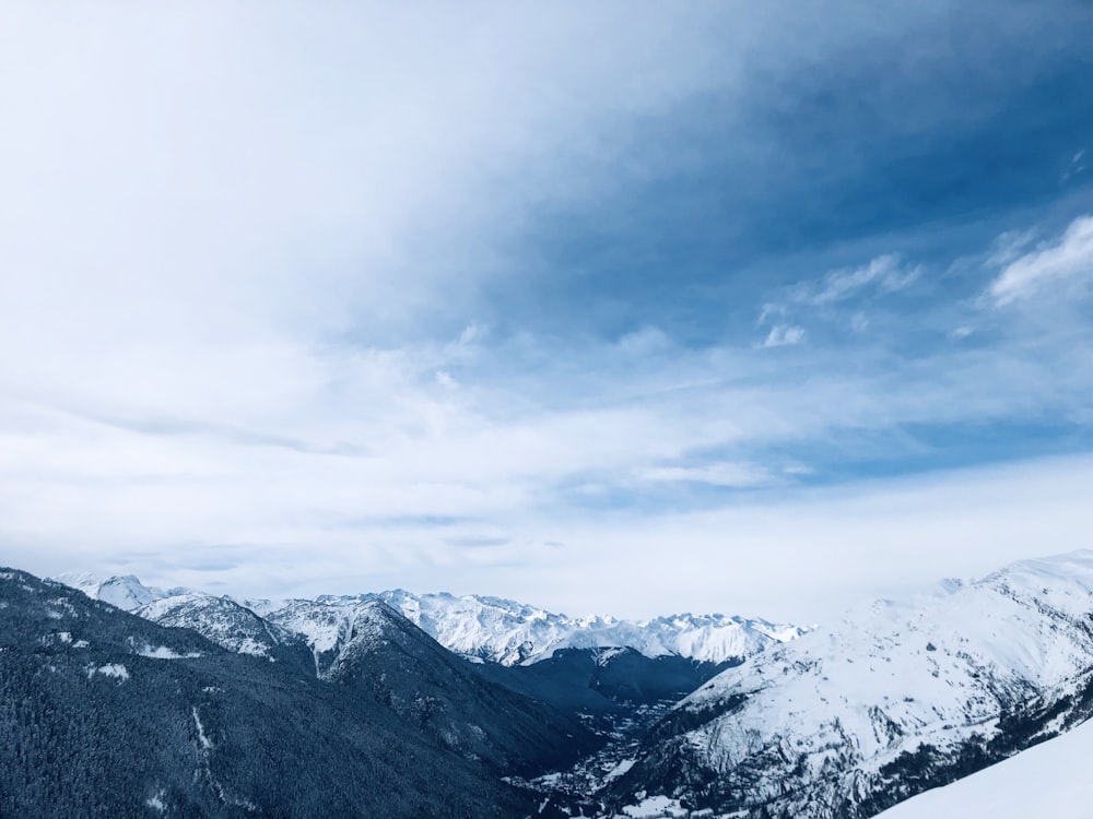 aerial photography of mountain covered with snow under white and blue sky during daytime