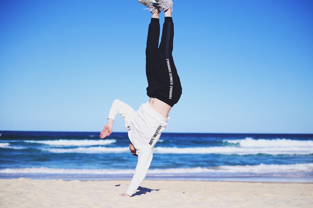 man doing cartwheel on sand