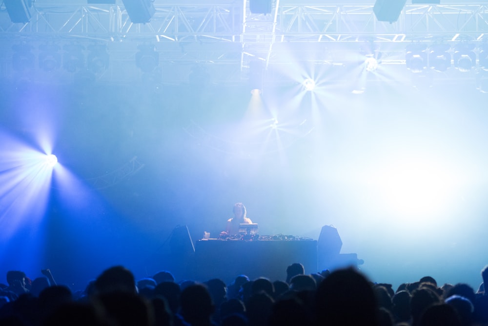 man performing on stage front of crowd