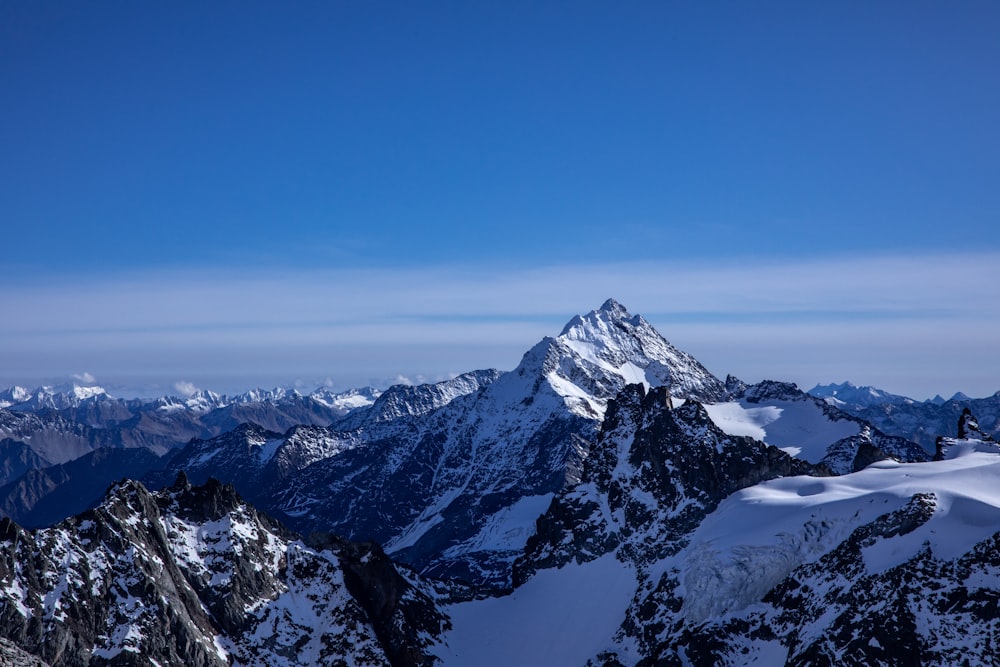 a view of a snowy mountain range from the top of a mountain