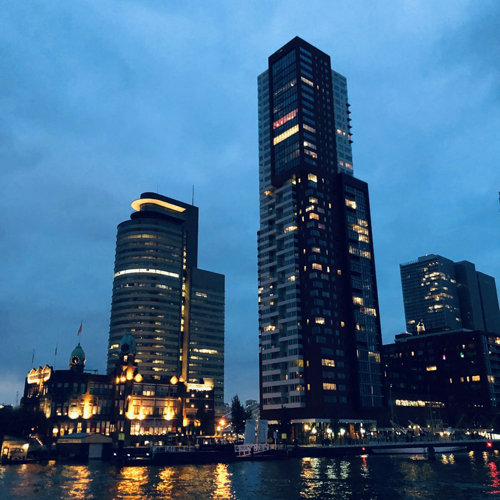 low angle photo of concrete building beside body of water