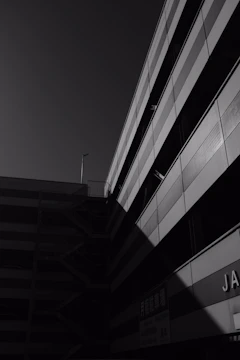 Black and white photo of a modern urban building with soft shadows and gradient lighting.