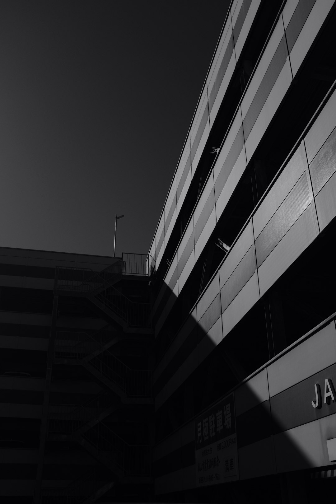 grayscale photography of buildings with sun shadow