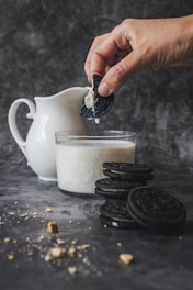 person holding biscuit dripping it in milk