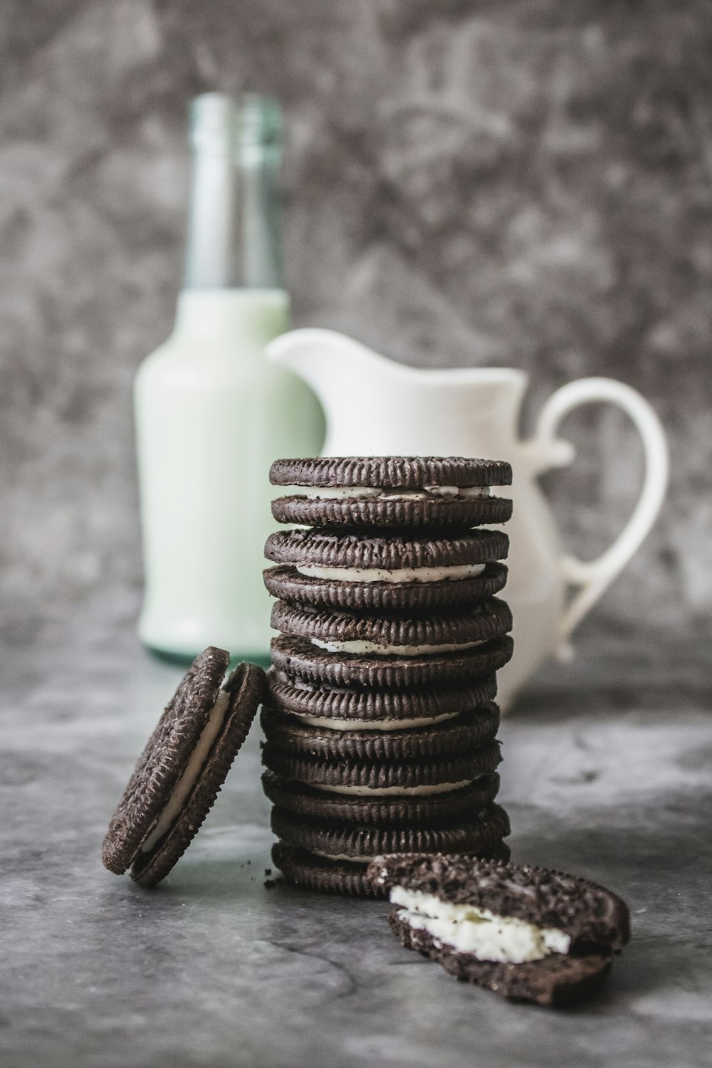 a stack of cookies next to a bottle of milk