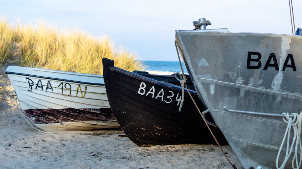 three gray, black, and white canoes