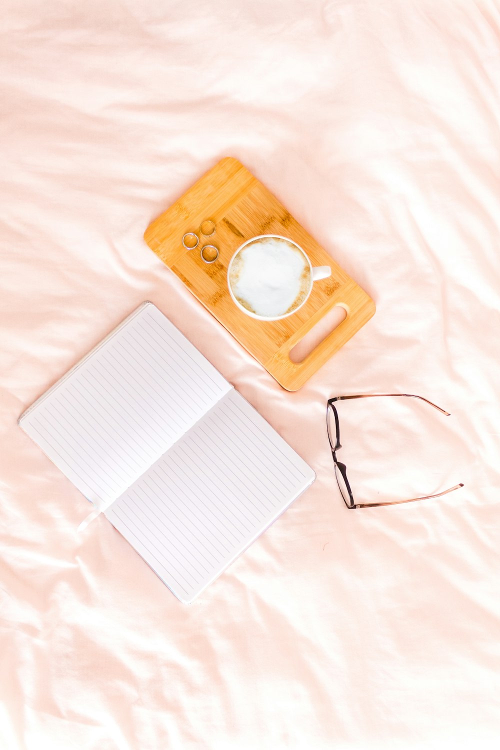 white notebook near eyeglasses