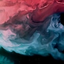 a red, blue and green fluid painting on a black background