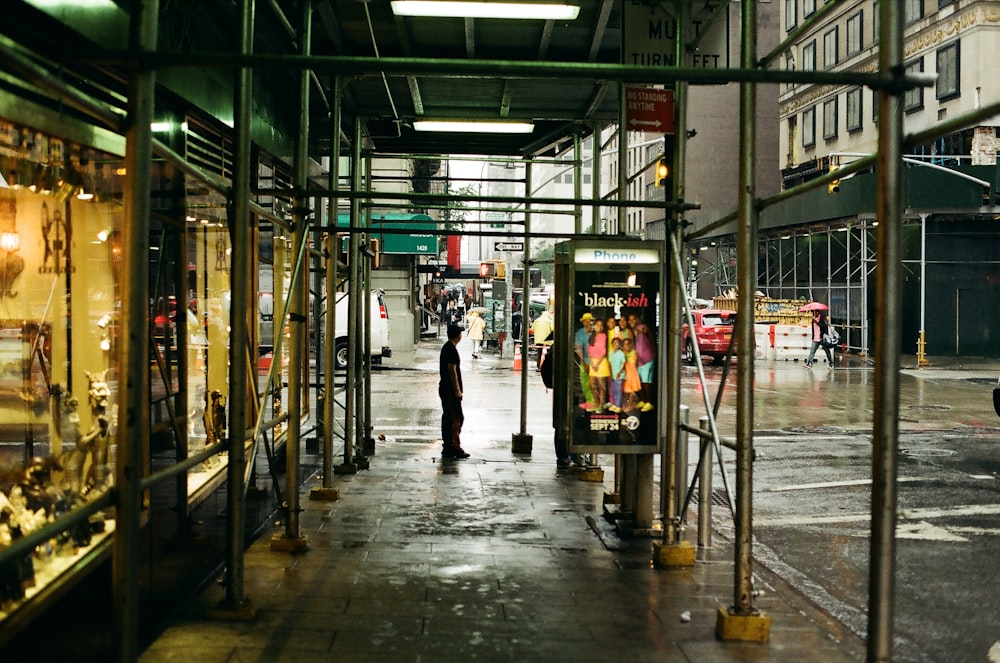 a man walking down a street next to a store
