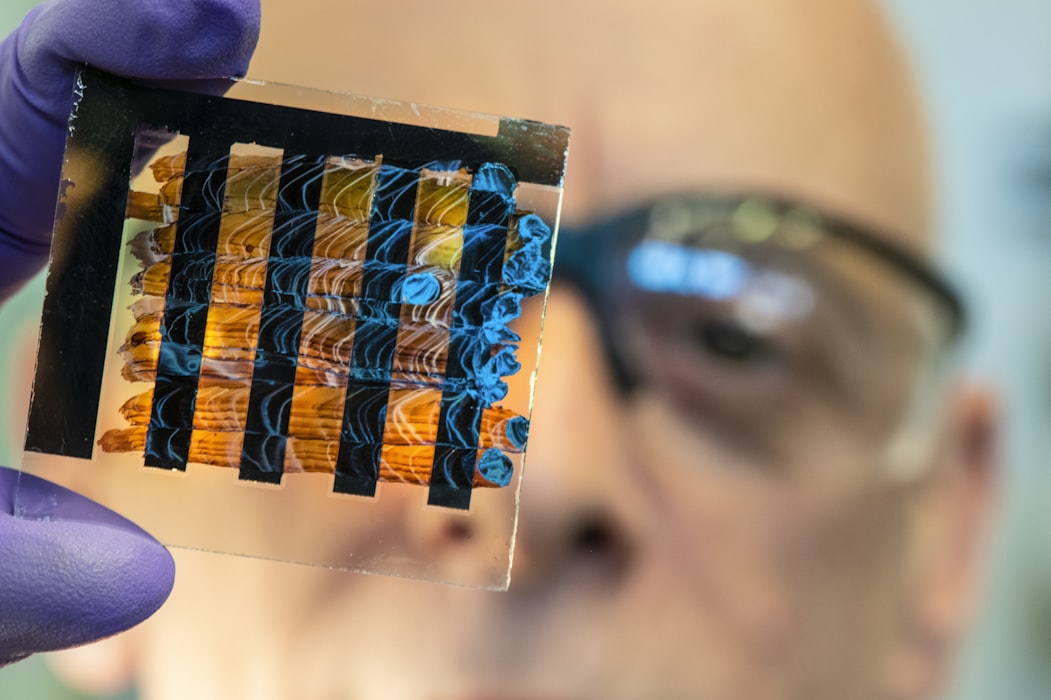 NREL researcher holds a perovskite ink painted cell.