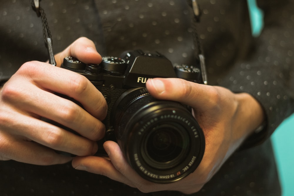 homem segurando a câmera Fujifilm