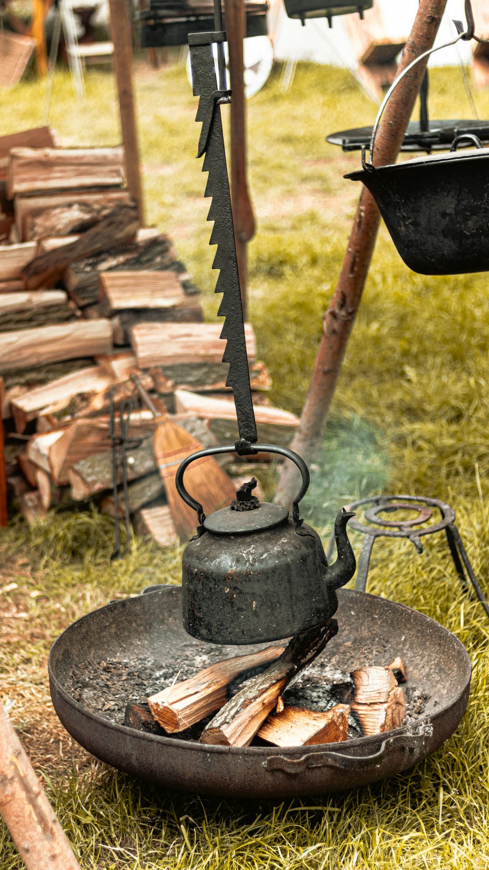 black steel kettle hanging on firepit