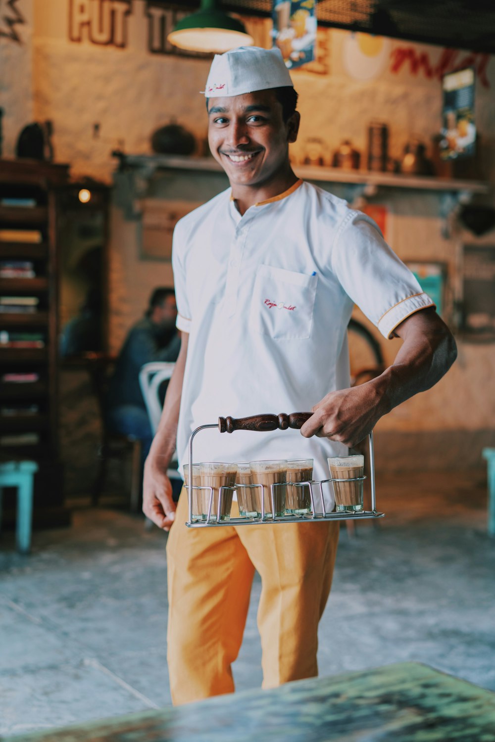 man holding tray of glasses