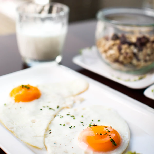 Protein-rich morning plate with fried eggs and granola