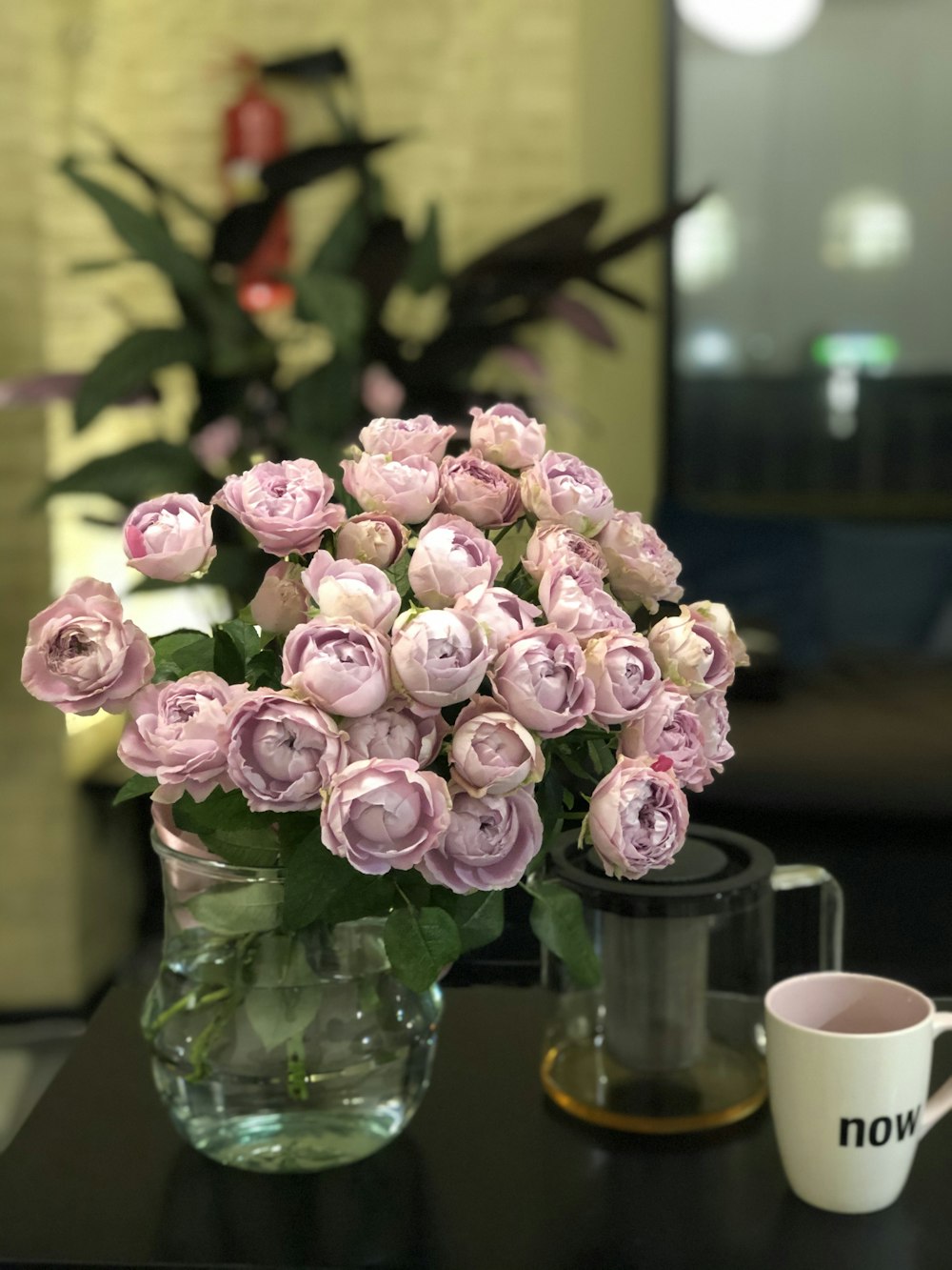 bouquet of purple roses in a clear glass vase ]