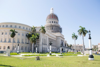 landscape photography of a dome building under a calm blue sky capital building teams background