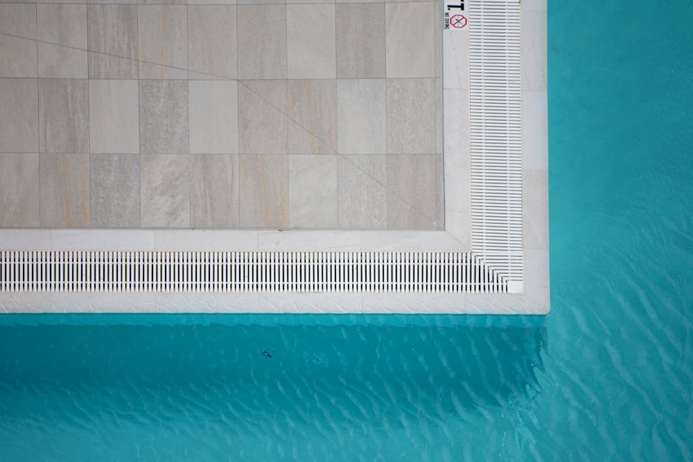 an overhead view of a swimming pool with a tiled floor