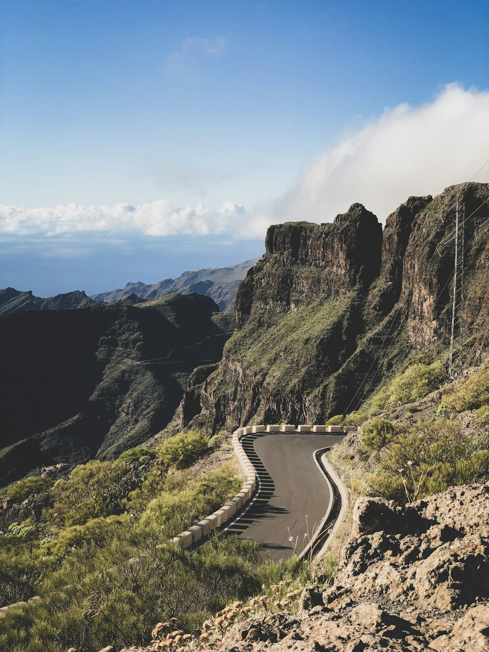 road on hill under cloudy sky