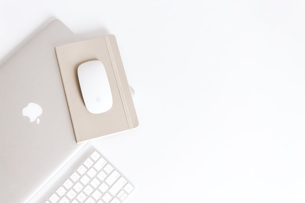 Apple Magic Mouse auf beigefarbenem Notizblock