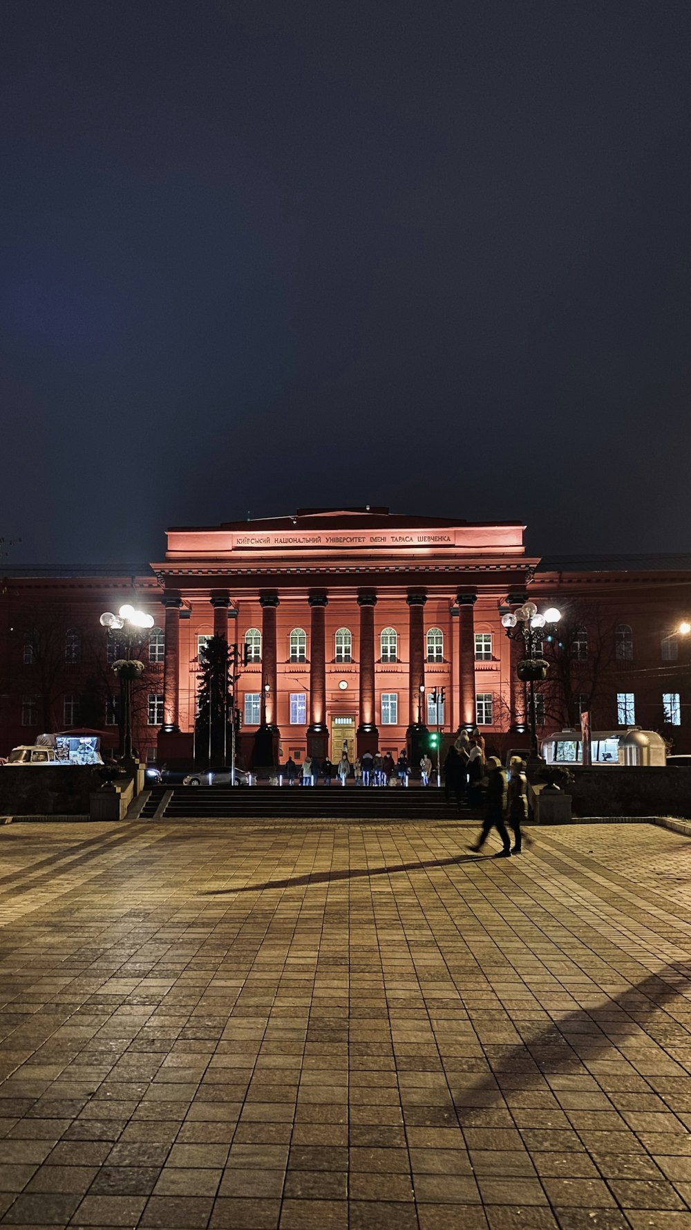 two person walking on plaza beside building