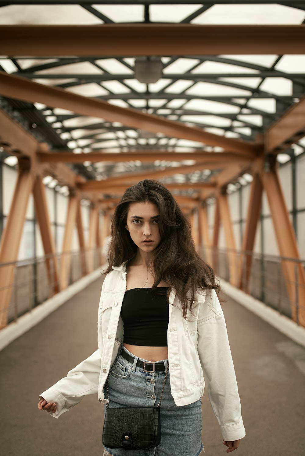 woman wearing white cardigan standing on the bridge