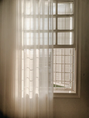 A serene, minimalist Parisian office space with soft natural light filtering through sheer curtains.