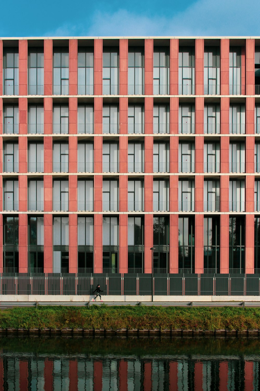 a tall building with lots of windows next to a body of water