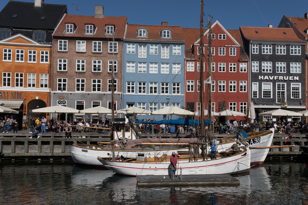 two white boats in front of buildings