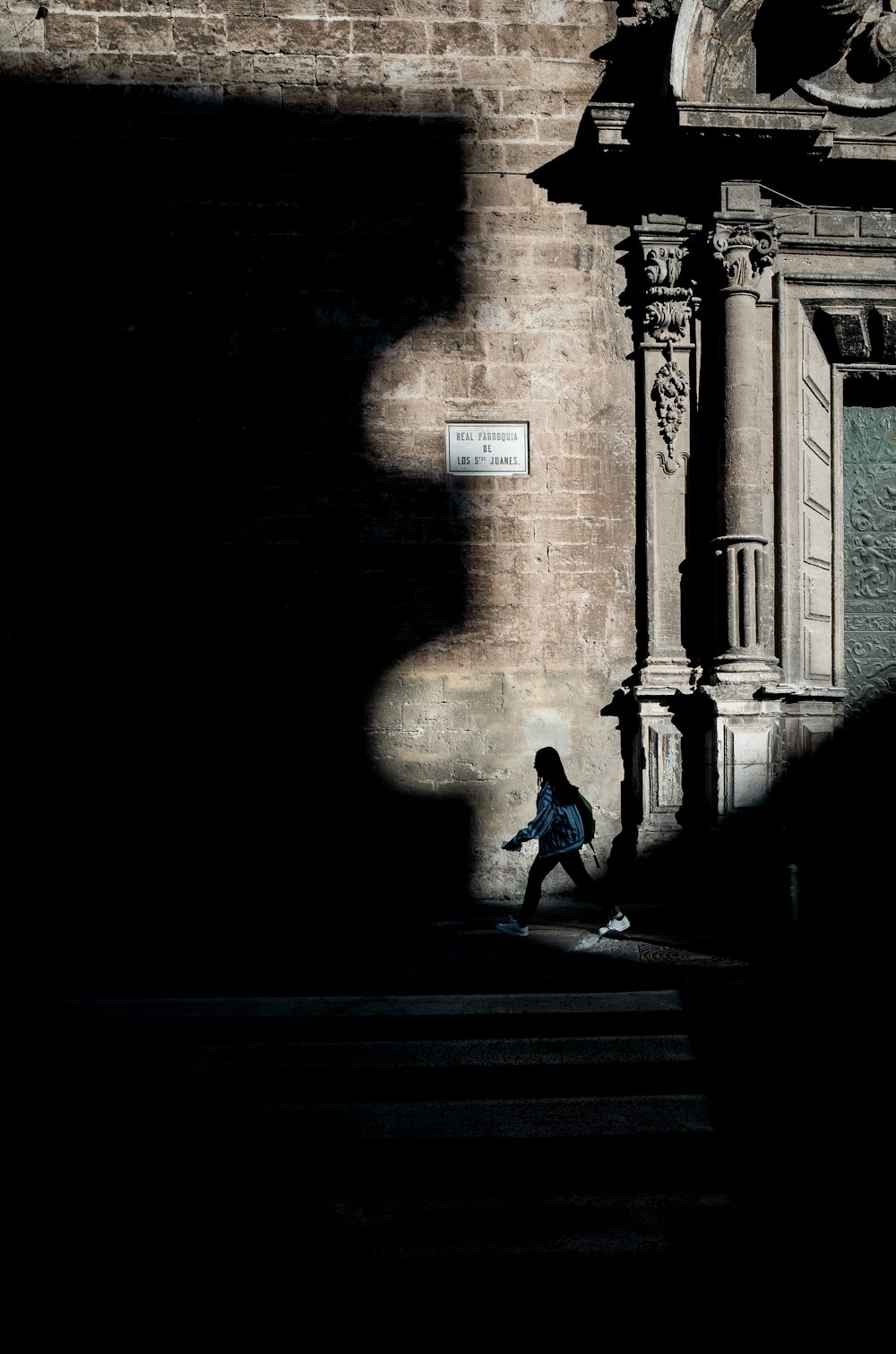 Mujer caminando en la acera cerca del carril peatonal