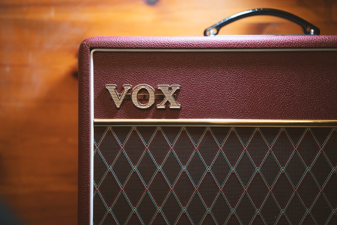 brown Vox amplifier beside wall