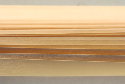 Abstract composition of layered paper textures in warm neutral shades.