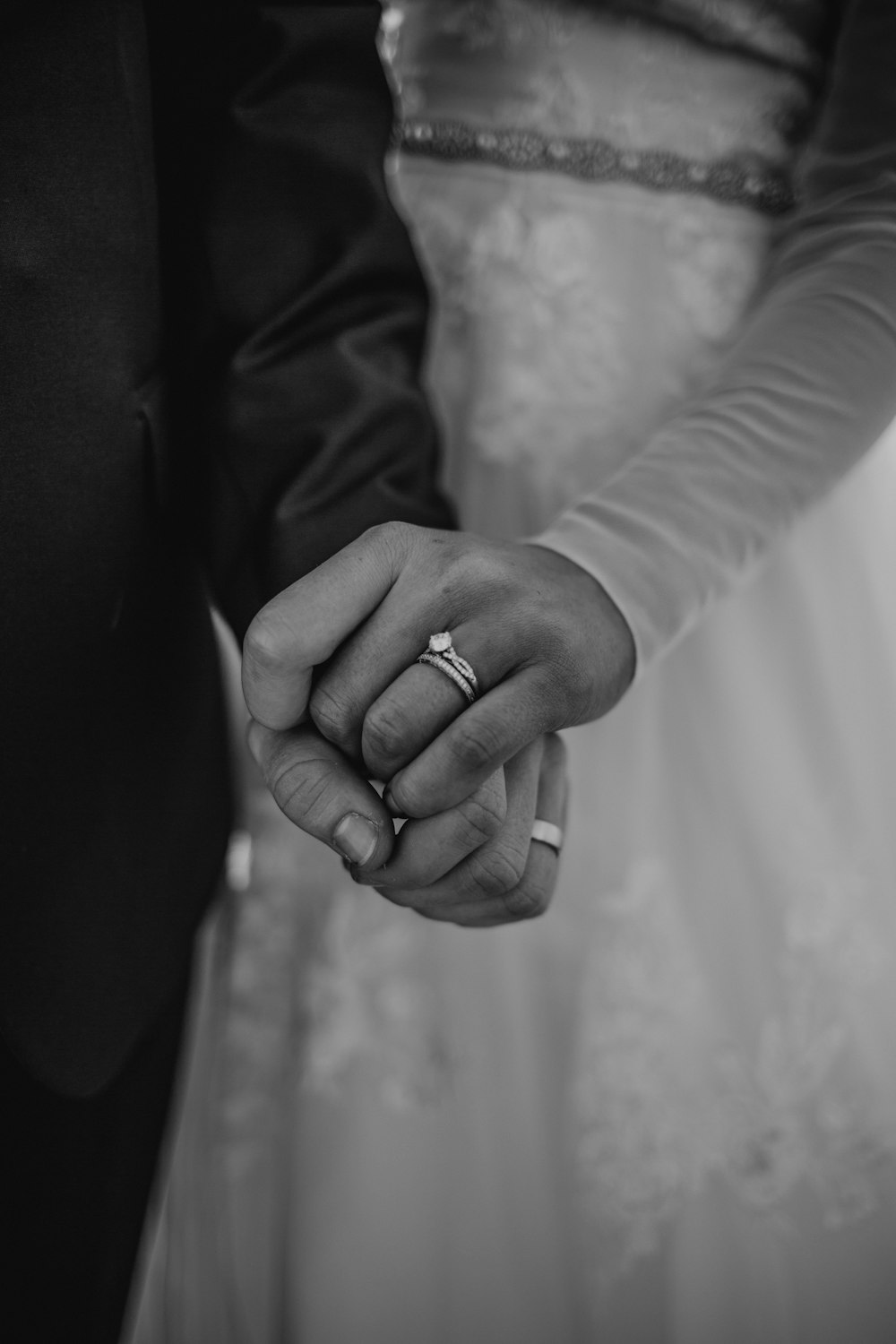 grayscale photography of man and woman holding hand
