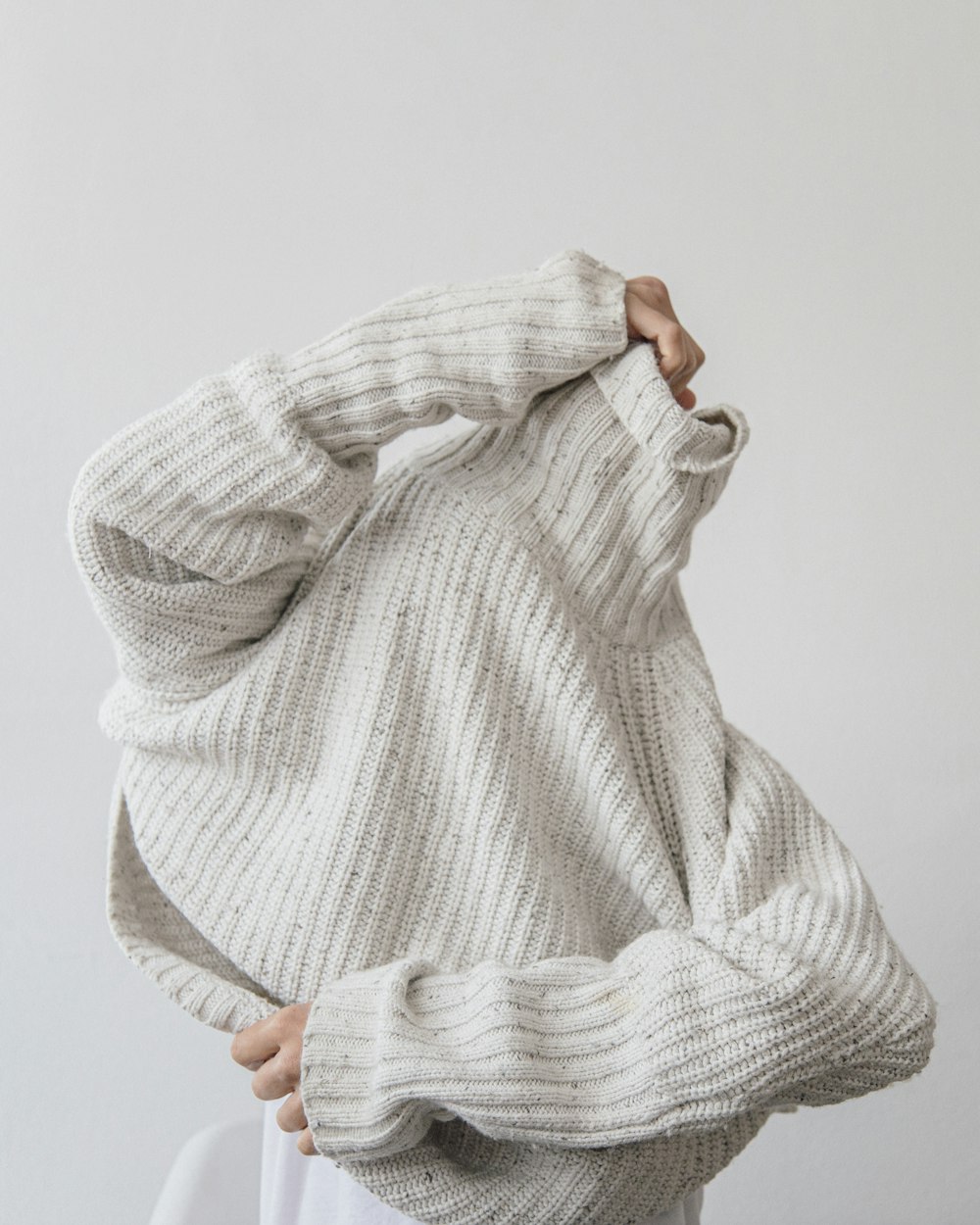 Person mit grauem Strickpullover