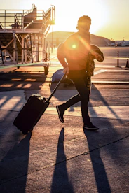 man walking with his black luggage bag