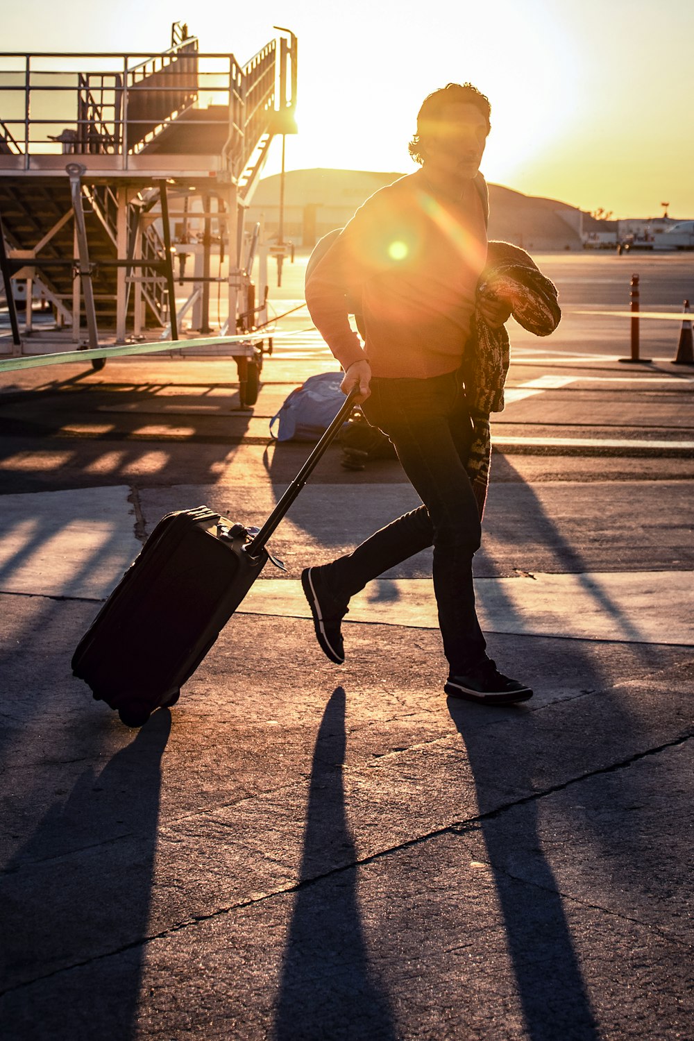 man walking with his black luggage bag