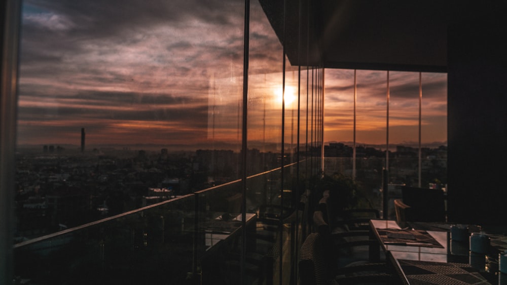 tables and chairs inside glass window building during sunset