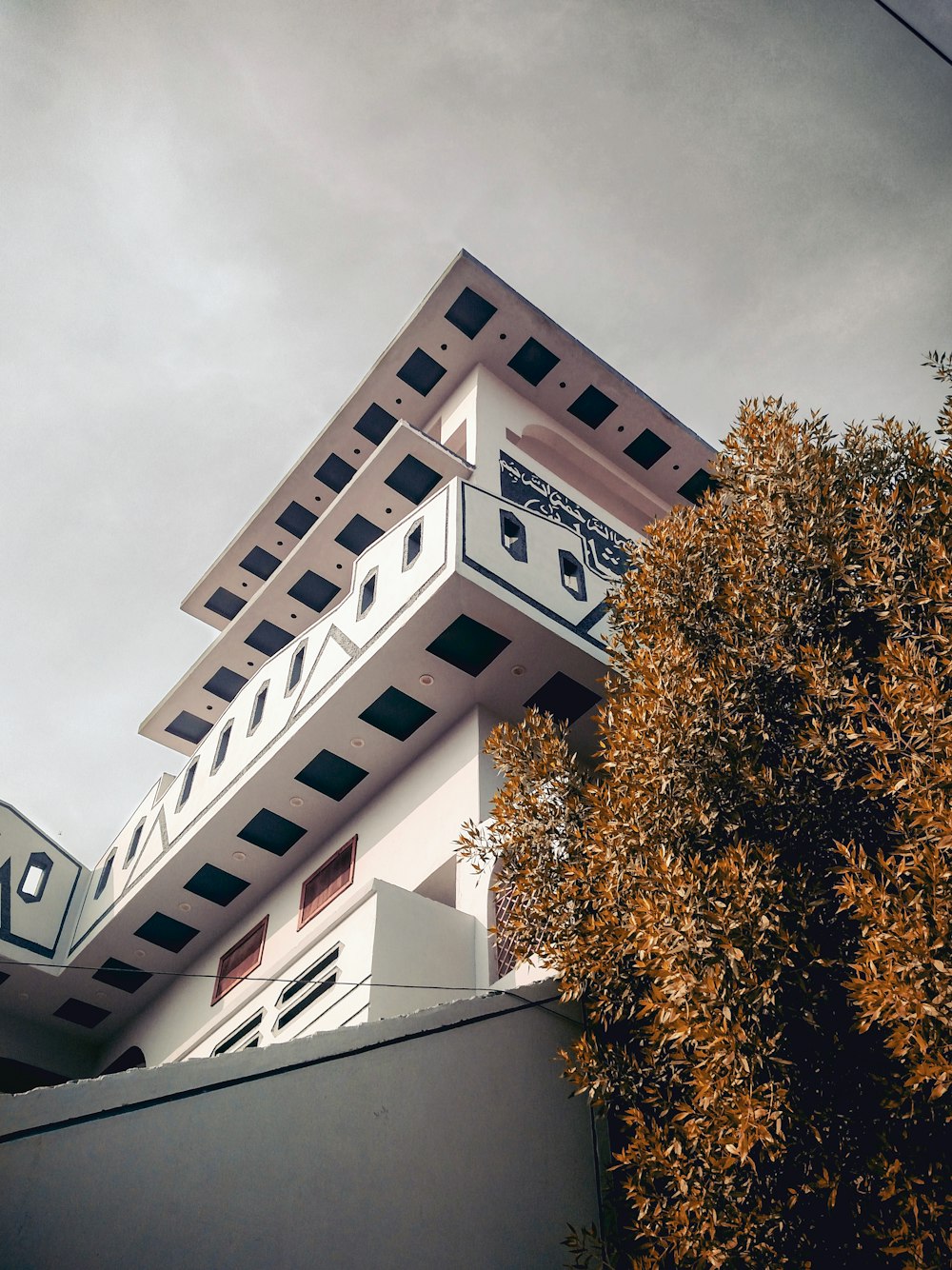 low-angle photo of white high-rise building during cloudy day