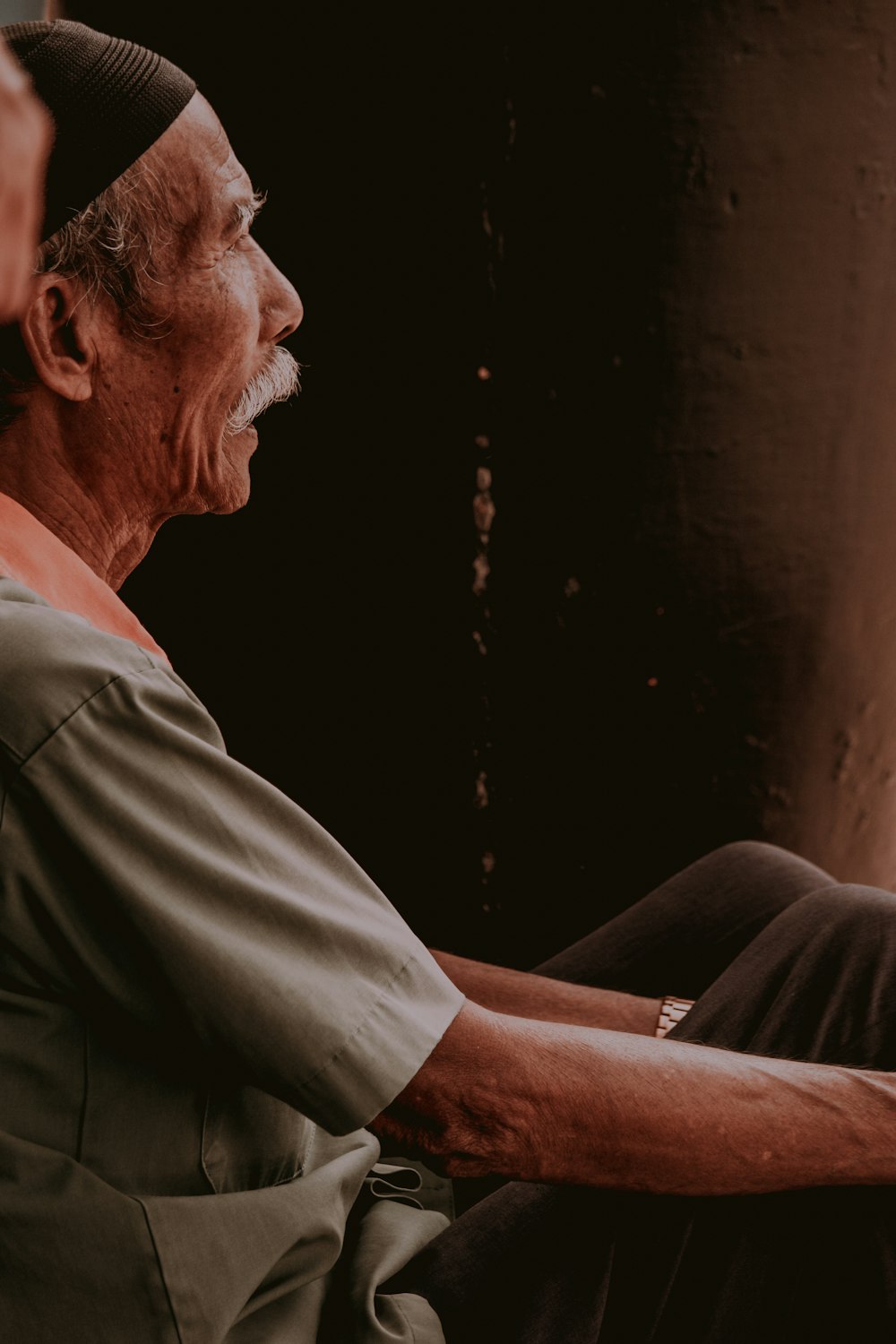 man in gray shirt beside wall