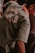 A person is wearing a green jacket with text that reads 'ST. JAKARTA KOTA PORTER' on the back. The jacket has an orange inner collar, and the person appears to be bending or sitting down.