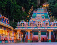 The colorful facade of Badrinath temple framed by the lush green Himalayan valley.