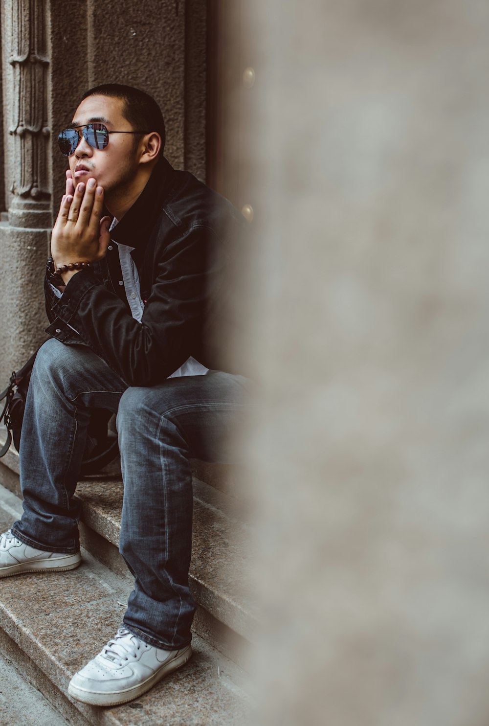 man wearing black jacket and blue denim jeans