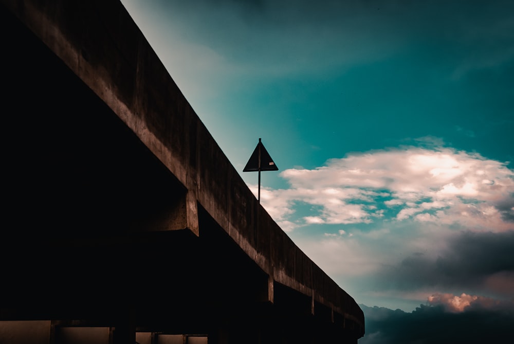 a street sign on the side of a road under a cloudy sky