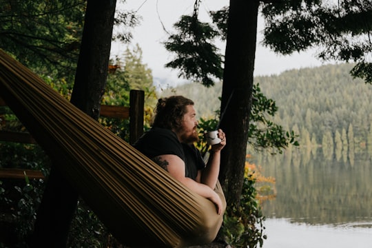 man sitting under tree in Sasamat Lake Canada