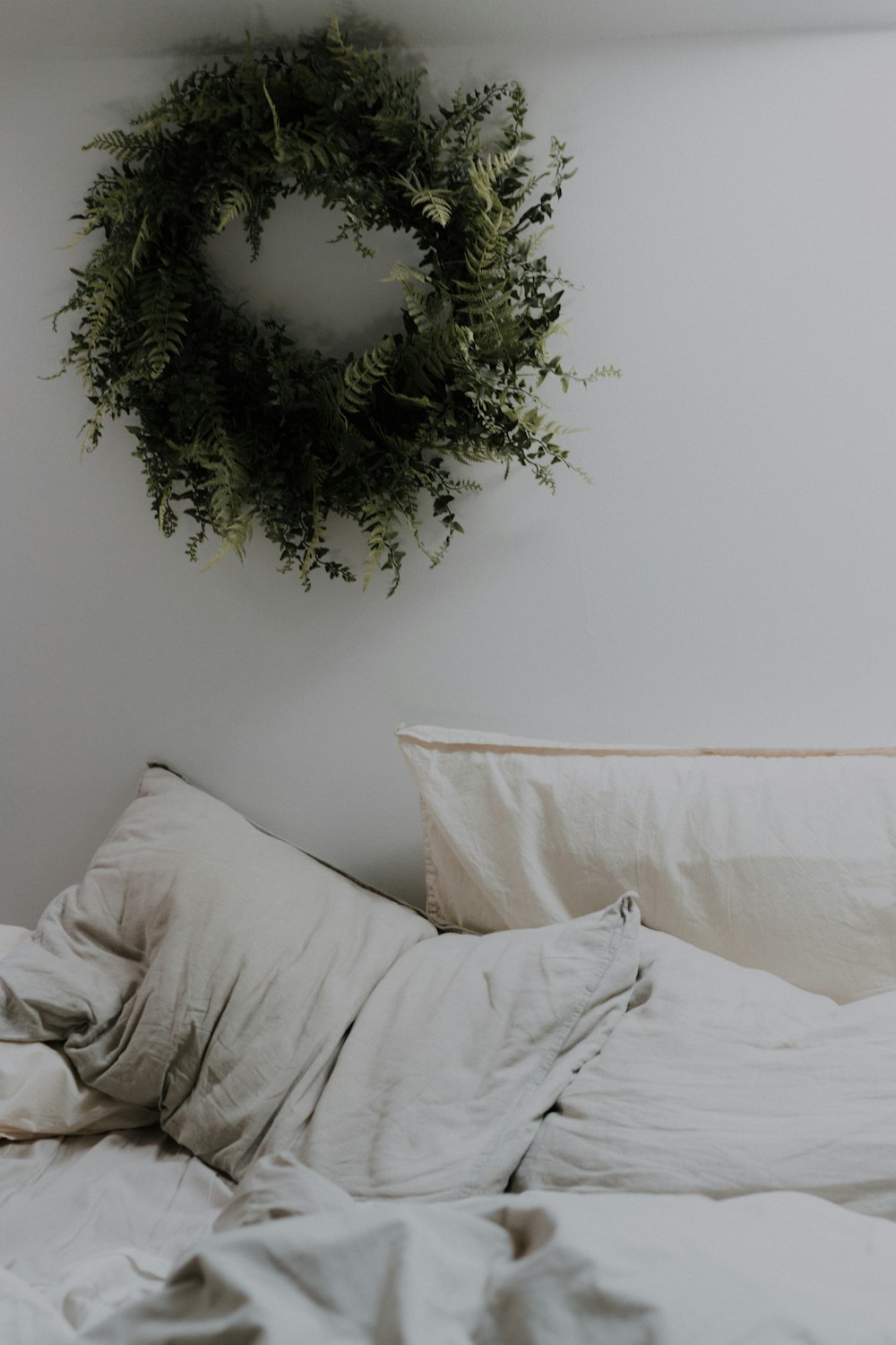 green wreath on wall near bed