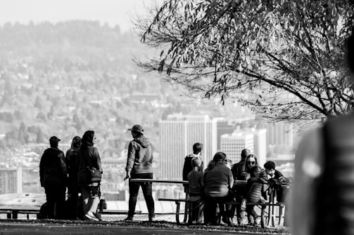 Group of students discussing observations under green trees in a city park