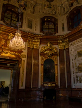 An intimate view of a sprawling mansion's ornate interior with classic chandeliers and tasteful décor.