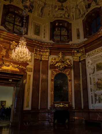 An intimate view of a sprawling mansion's ornate interior with classic chandeliers and tasteful décor.